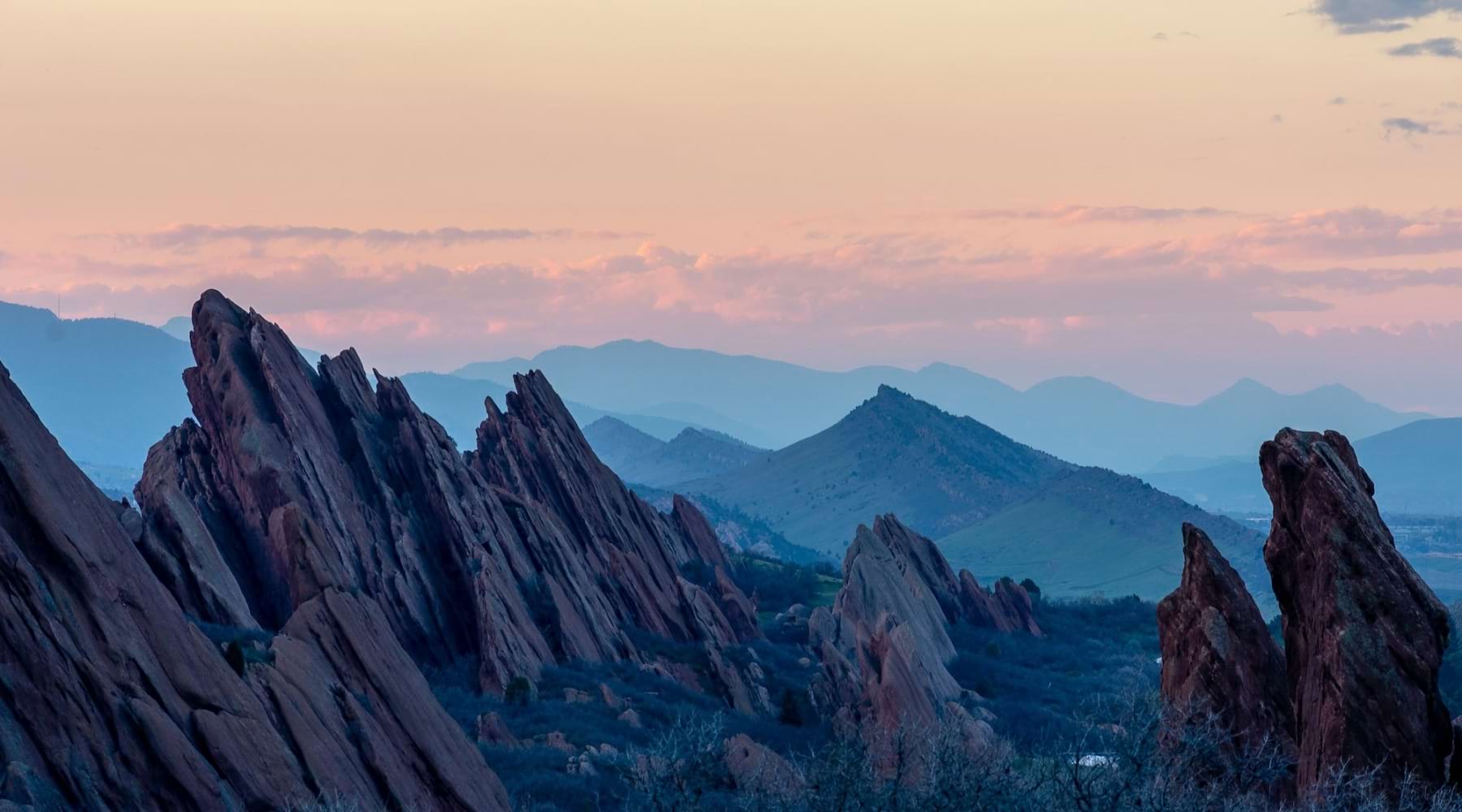 cliff faces with mountains in the distance at dawn