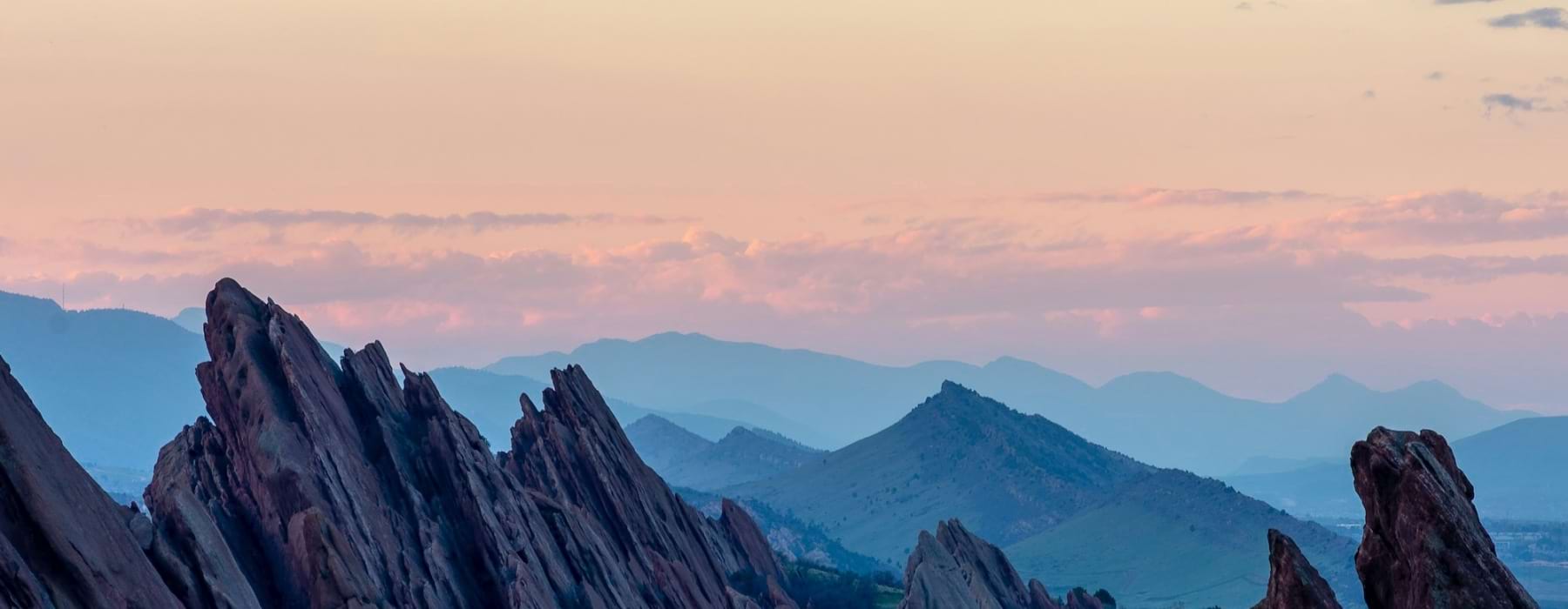 cliff faces with mountains in the distance at dawn
